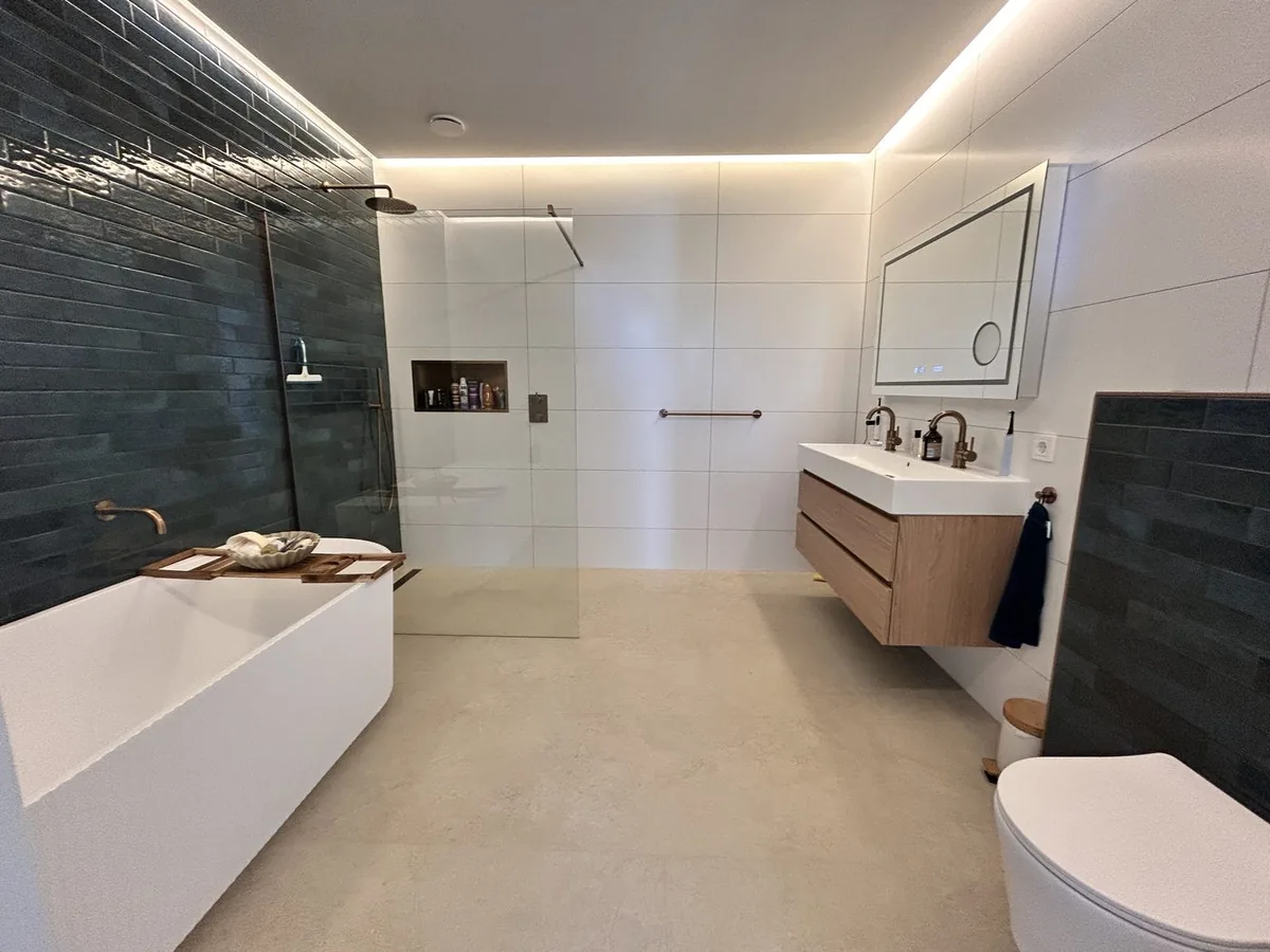Opgeleverde badkamer met een inloopdouche, een vrijstaand bad en een zwevend meubel
