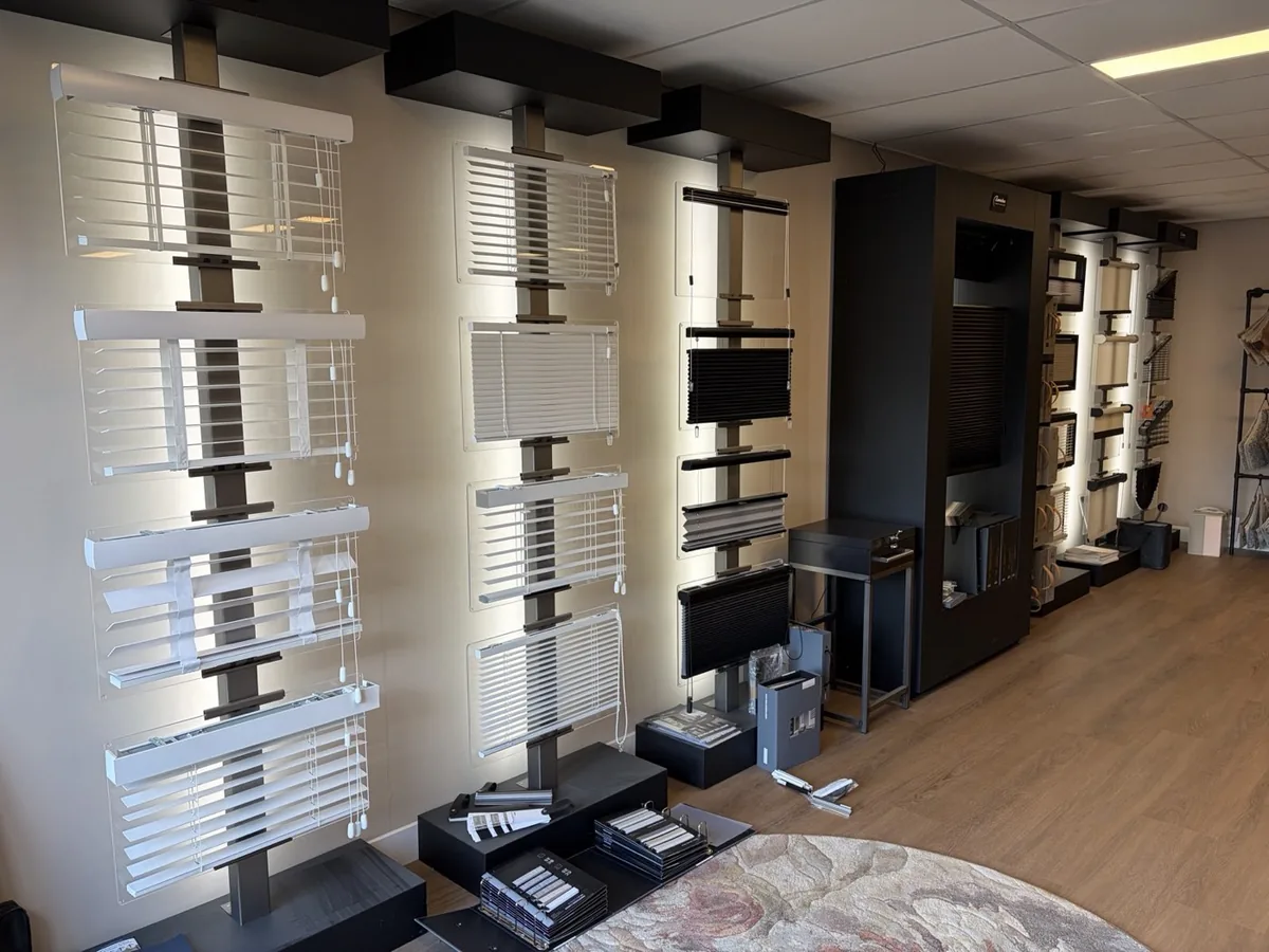 Wand met jaloezieën en plissés in de showroom