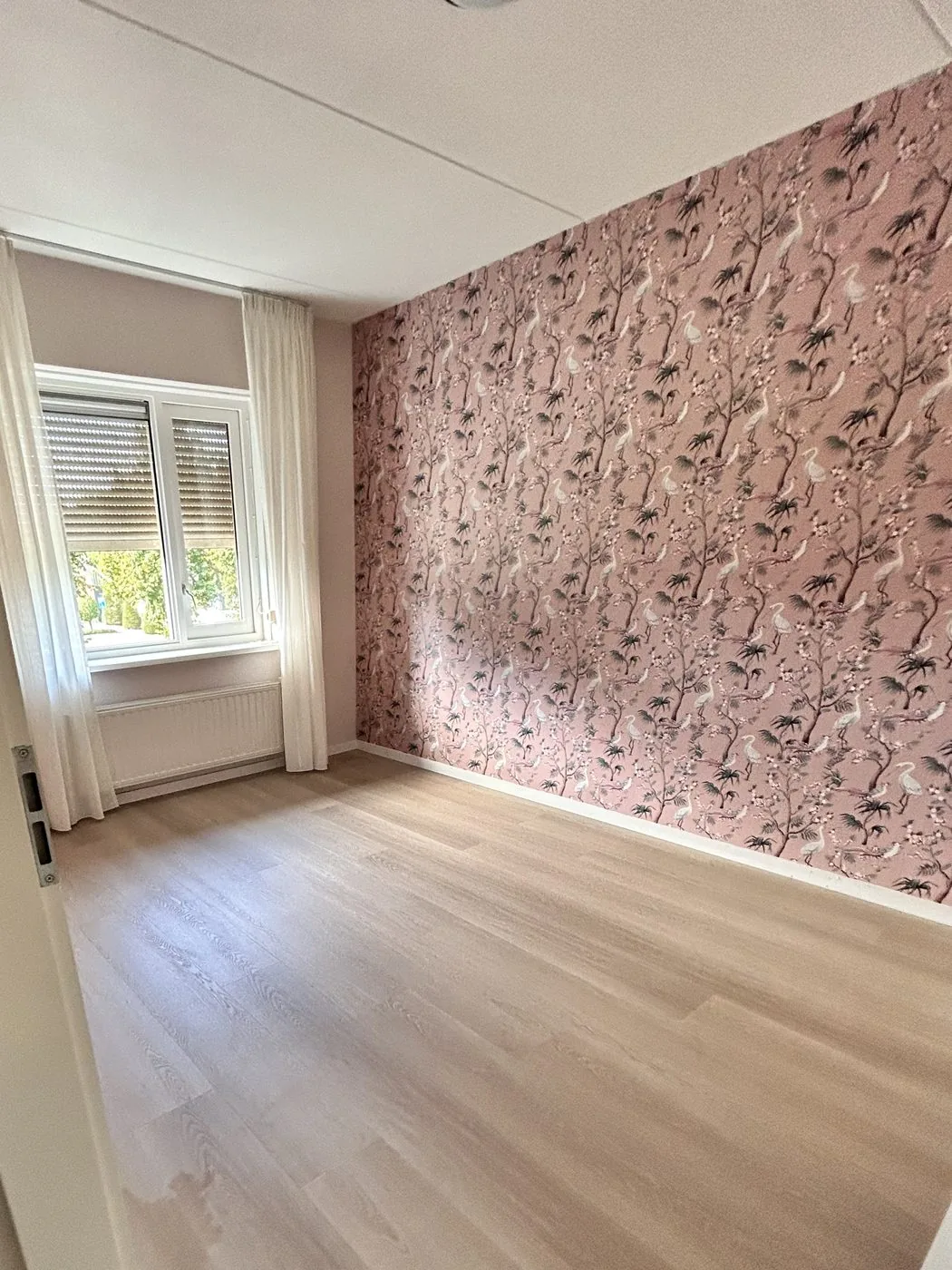 Kamer met een lichte pvc-vloer, afgewerkt met witte plinten