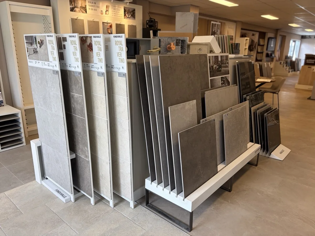 Grote tegels in verschillende tinten in het rek van de showroom
