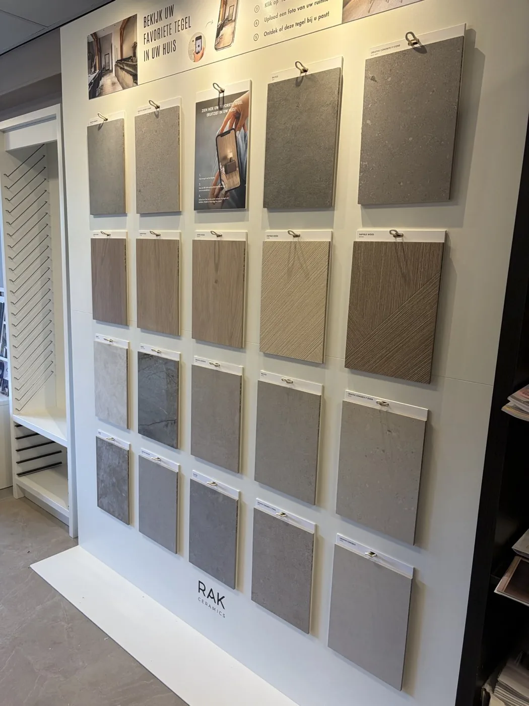 Wand met tegelstalen in grijze en beige tinten in de showroom